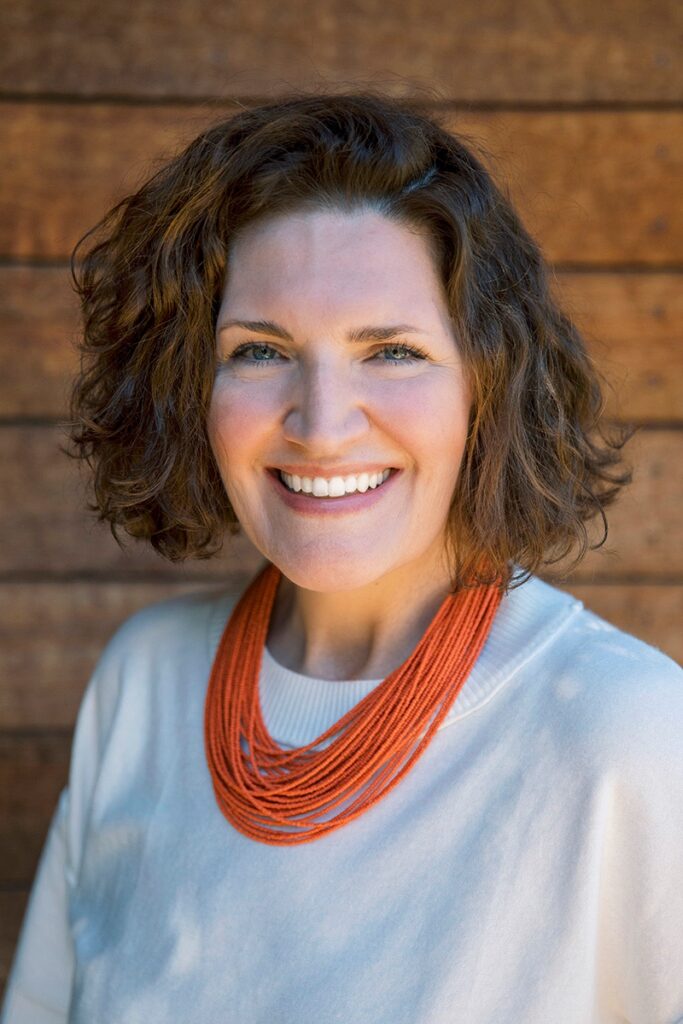 Kirsten K. Hammann, experienced nonprofit strategist, smiling in front of a green ivy-covered wall.