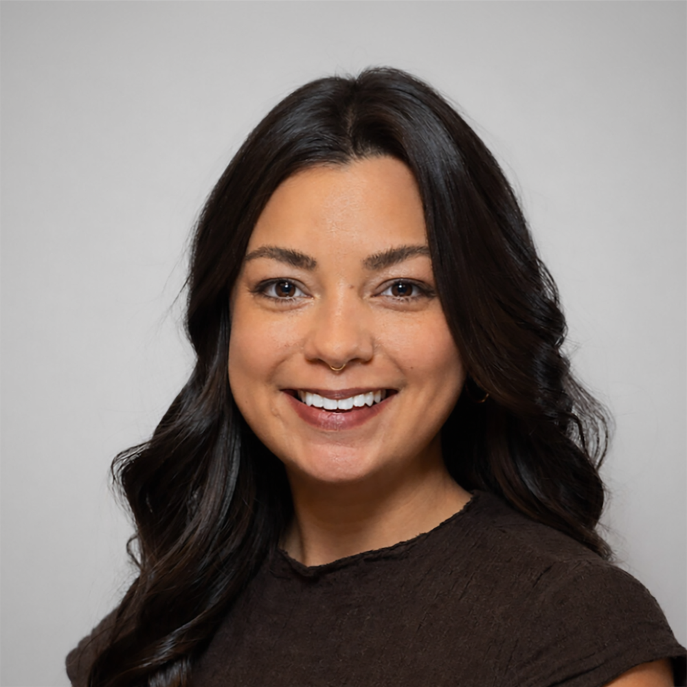 Haley Aniceta Eligio is smiling in front of a white backdrop.