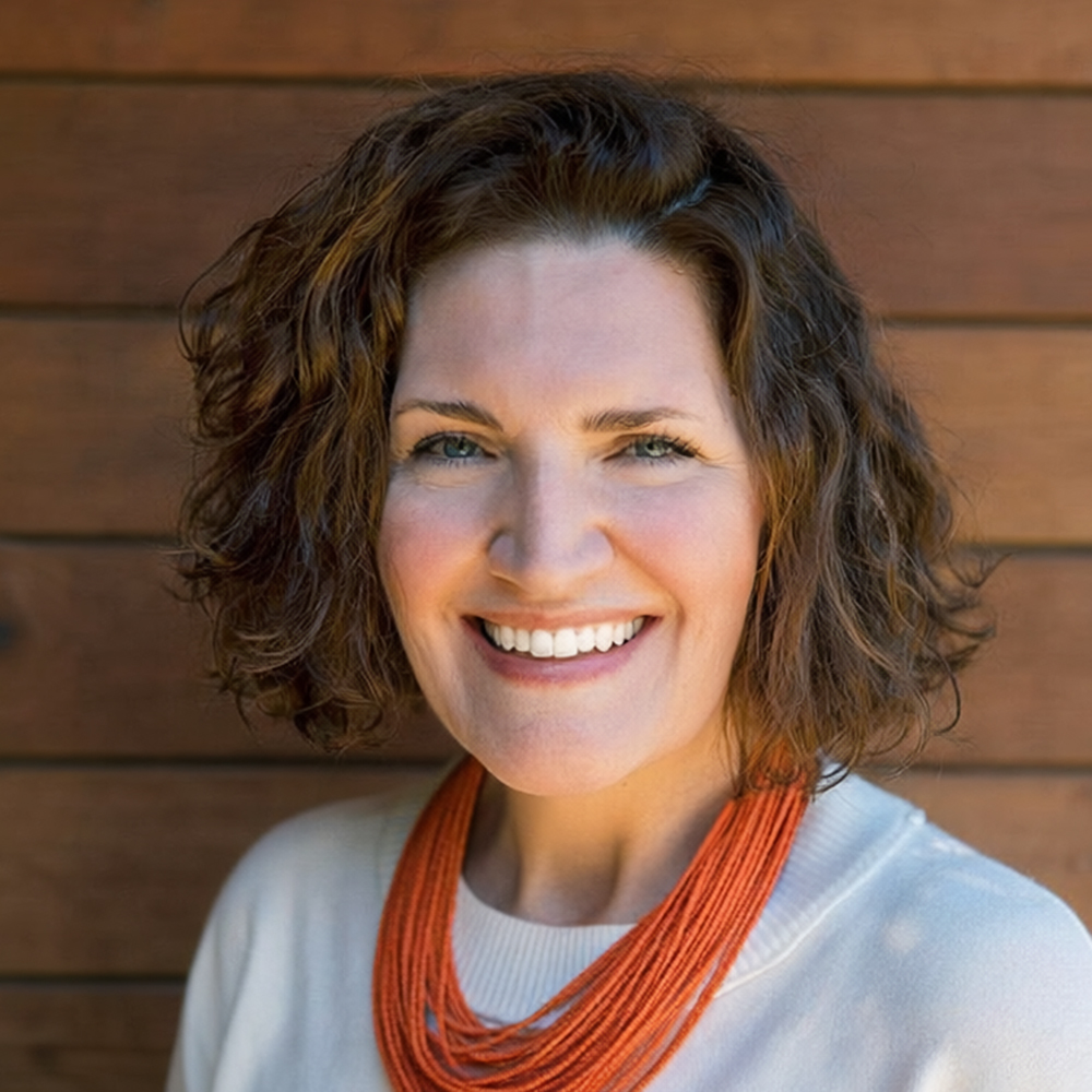 Kirsten K. Hammann is smiling in front of a wood-panelled wall.